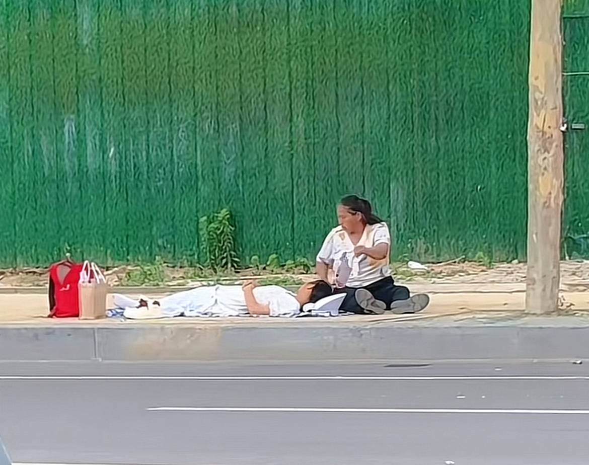 菏泽一高考考生午休躺在路边休息，家人在旁不停扇扇子感动网友 ，拍摄者：递了两瓶水